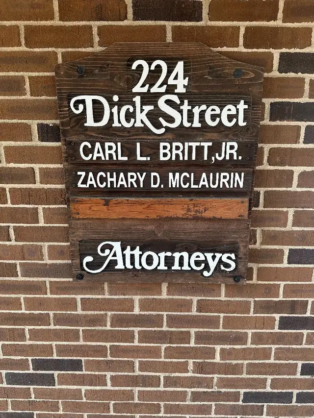 The firm's wooden door plaque at 224 Dick Street